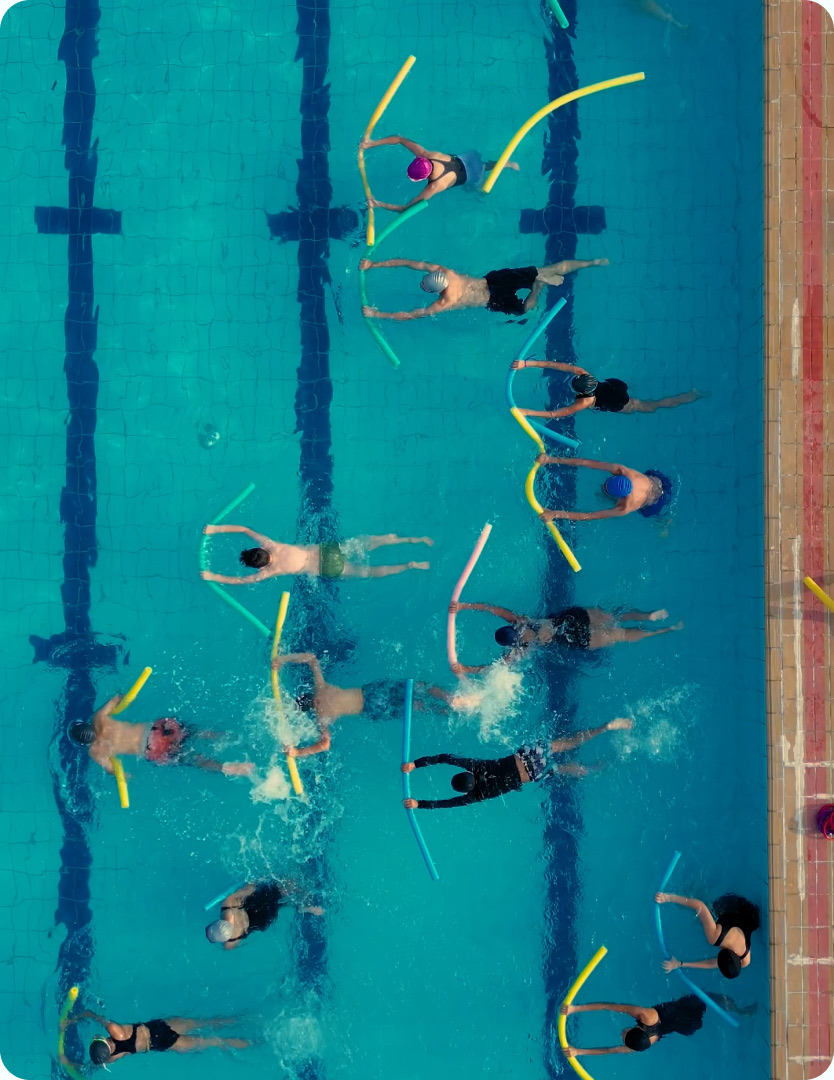 Aquafitness-Gruppe mit Poolnudeln von oben