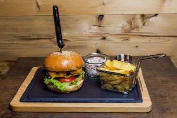 Burger mit Pommes auf einem Holzbrett
